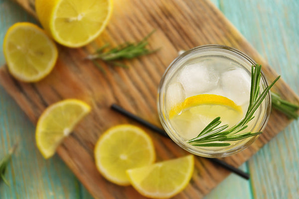 Cold fresh cocktail with lemon on cutting board